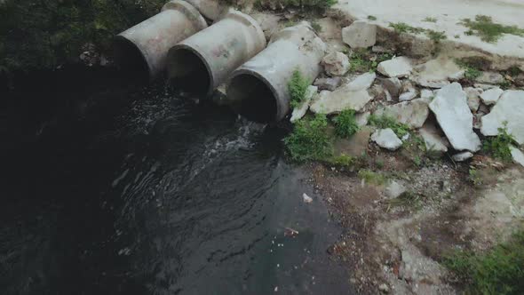 Flying over concrete sewers. Streams of water flow through concrete pipes. alt