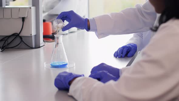 Scientists with Chemicals Working in Laboratory