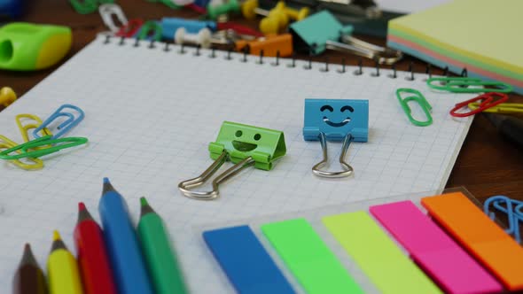 Smiles Blue and Green Binder Clips on Notebook with School Office Supplies