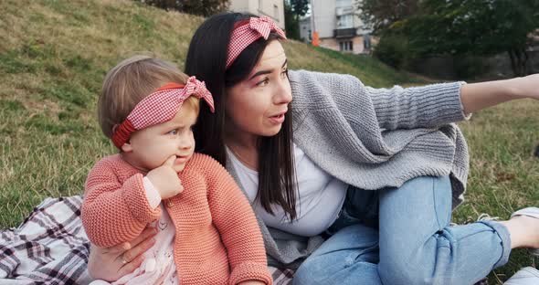 Mother and a Small Daughter, Spends Time Together in a City Park on a Picnic. Young Woman and Little