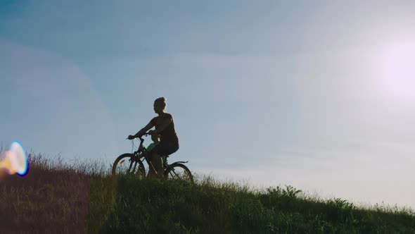 The Family Rides Bicycles in Nature at Sunset alt