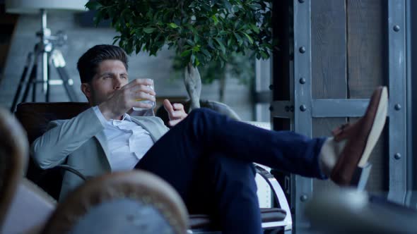 Satisfied Businessman Resting Armchair in Luxury Interior alt