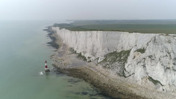 Spectacular aerial drone view of isolated lighthouse beside white chalk cliffs in Beachy Head shorel alt
