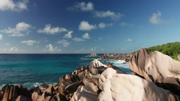 Aerial dolly pull back extremely close to jagged pink granite boulders