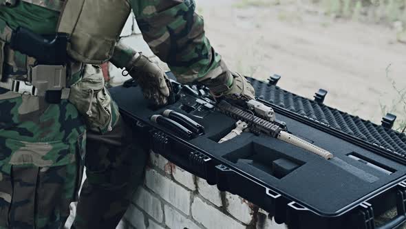 The Soldier Pulls a Rifle Out of the Ammunition Case and Insert Ammunition Clip Into Assault Rifle alt