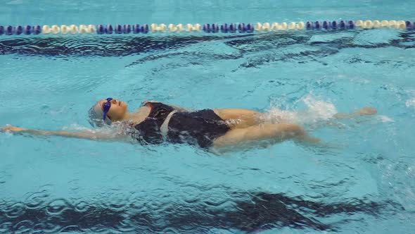 Training Of Female Amateur Swimmer Doing Backstroke In Swimming Pool