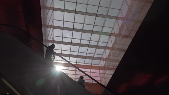Escalator with people in shopping mall alt