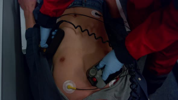 Paramedic Hands Using Defibrillator alt