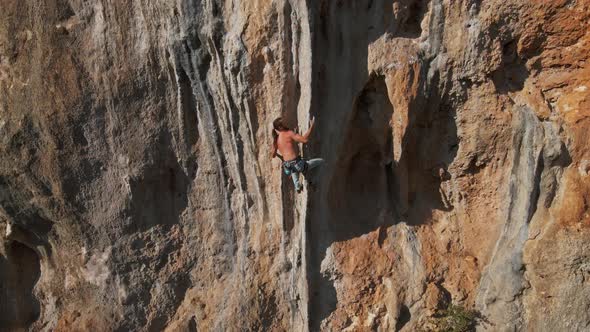 Slow Motion Aerial Drone Footage of Strong Man Rockclimber Climbing Up on Tough Hard Route on alt