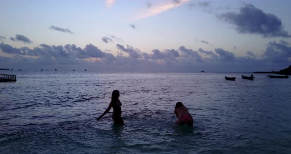Young fun women on holiday by the sea at the beach on summer white sandy and blue 4K background alt