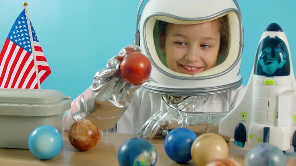Smiling Child Holding a Red Planet Mars Space Rocket in His Hands Closeup Pilot Traveling Into Space alt