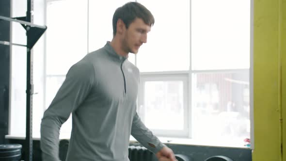 Young Guy in Sportswear Jumping with Skipping Rope in Gym Working Out Alone alt