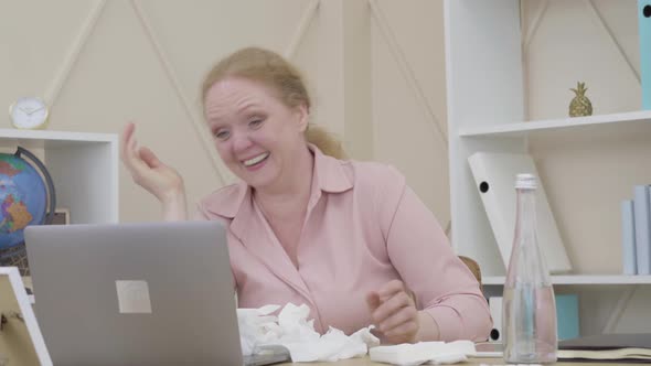 Portrait of Senior Woman Laughing Out Loud As Sitting at the Table with Pile of Used Tissues alt
