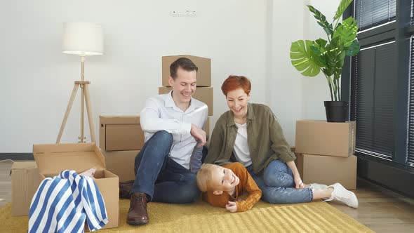 Young Family with Little Child Sit on Warm Floor Relaxing Together in Own Apartment Overjoyed Family alt