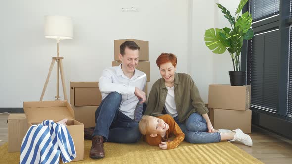 Young Family with Little Child Sit on Warm Floor Relaxing Together in Own Apartment Overjoyed Family