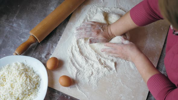Close-up Hands of Senior Female Is Kneading a Dough at Home Kitchen, Above View