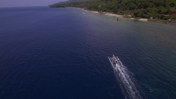 Aerial view of a fishing boat in clean blue water. Nusa Penida island, Indonesia. alt