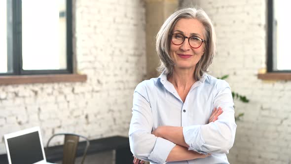 Positive Businesswoman Standing with Arms Folded alt
