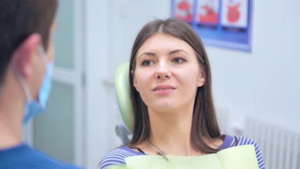 Smiling Patient Listening To Dentist's Advice in Dental Office
