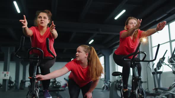 Healthy Caucasian Group of Women Exercising Workout on Stationary Cycling Machine Bike in Gym alt