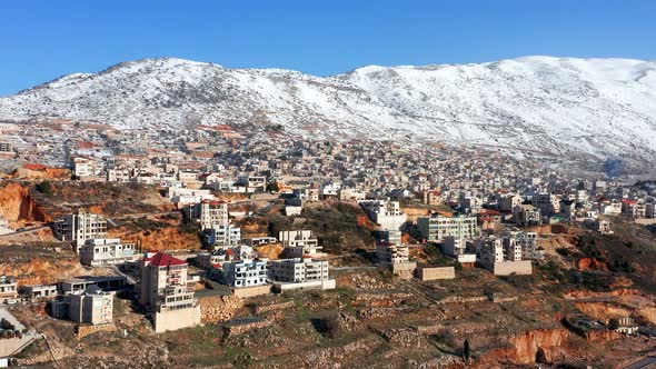 Hermon mountain ridge covered with snow during 2022 winter, with the town houses of Majd al Shams. alt