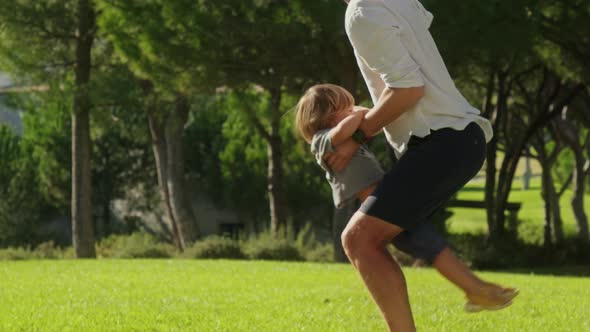 Cheerful Family of Son and Father Playing with Dense Forest Behind alt