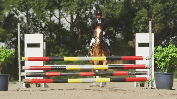African American man jumping an obstacle with his Dressage horse alt