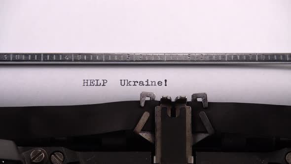 Typing phrase "HELP Ukraine !" on retro typewriter. alt