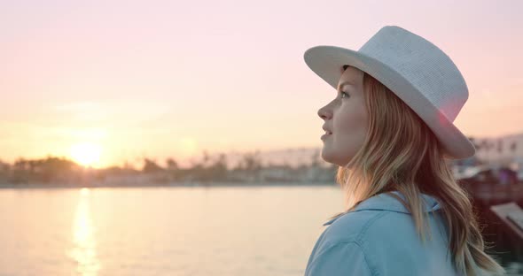 Close Up Portrait of Smiling Woman Enjoying Beautiful Rose Gold Sunset at Ocean alt