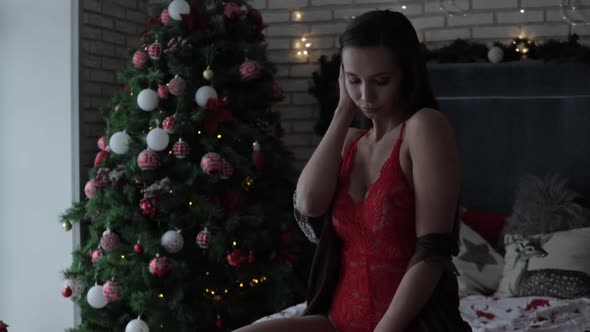 Sensual Young Woman Resting at Home in Different Underwear During Christmas Holidays