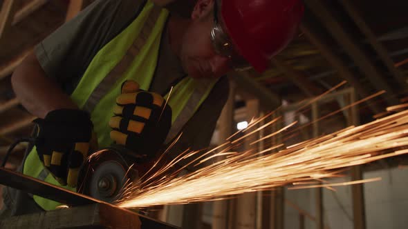 Construction worker grinding metal and making sparks