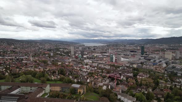 Forward rising aerial over the cityscape of Zurich in Switzerland, cloudy day. alt