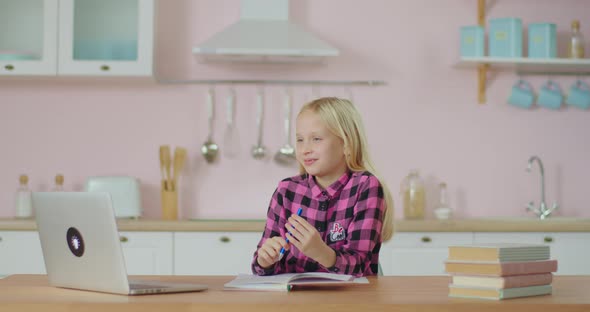 School Kid Studying Online on Laptop at Home. Blonde 10 Years Old Girl Learning with Distance School