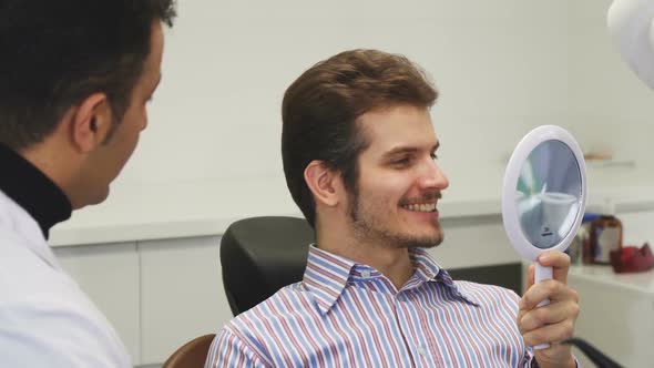 Happy Young Man Checking Out His Healthy Smile at the Dental Office alt