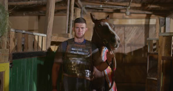 Portrait a Russian Soldier in Chain Mail Leads a Horse with a Shield and Spears alt
