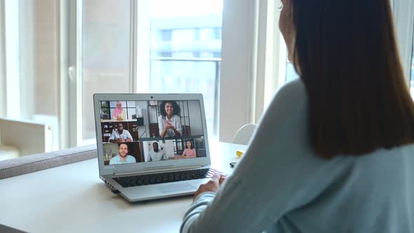 Young Woman Using Laptop for Video Meeting with Group of Diverse People alt