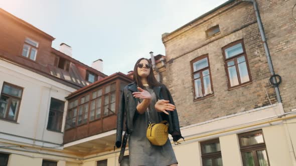 Young Happy Beautiful Girl Is Smiling and Dancing Emotionally on the Street of the City. alt