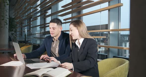 Man and a Woman Discussing Work in the Brightly Lit Modern Office. Concerned Male and Female Working