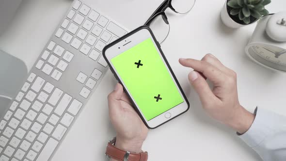 Businesswoman 's hands  working and touch screen the green screen on smartphone