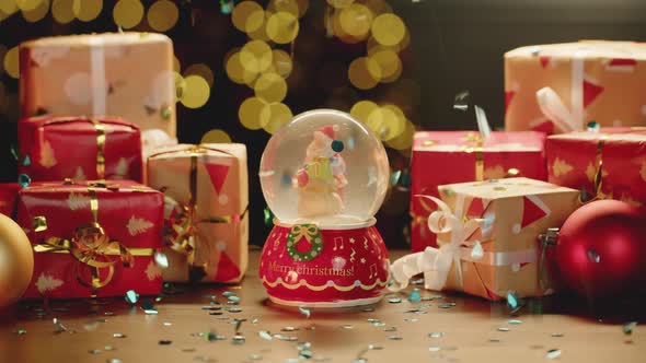 Christmas Snowglobe and Christmas Gifts on Table