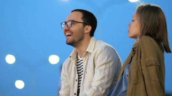 Girlfriend and Boyfriend Sitting on Bench Talking and Smiling alt