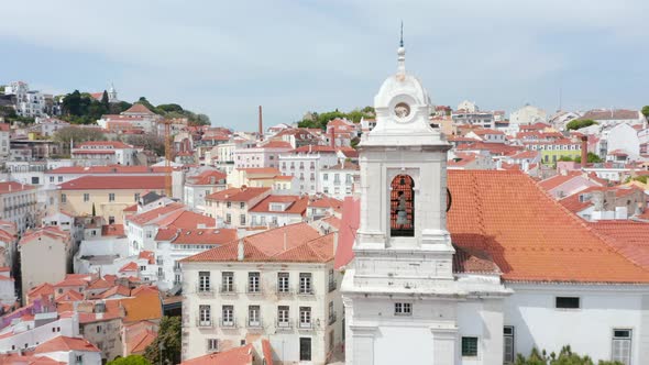 Aerial Dolly Out View of Bell on the Church Surrounded By Colorful Houses in Urban City Center of alt