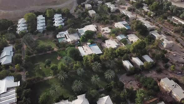 Aerial: drone view over the rooftops of the village of Yotvata, Israel alt