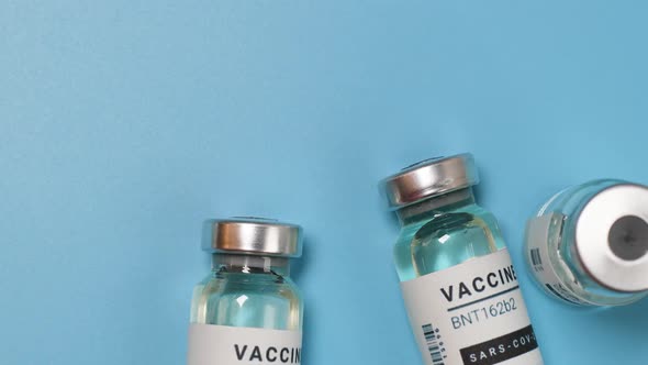 Vaccine Vials or Coronavirus Vaccination Bottles on Blue Background