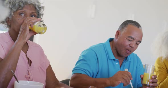 Happy senior diverse people having breakfast at retirement home alt