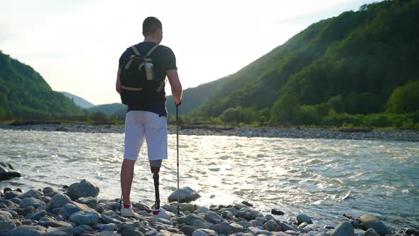 Handicapped Backpacker Admiring River and Mountain Scene
