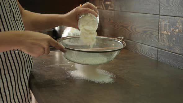 Sieving flour on the kitchen countertop alt