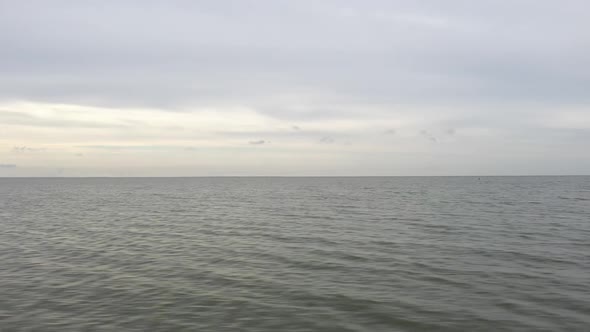 AERIAL: Panoramic Fast Flying Over Sea with Cloudy Grey Sky in Horizon alt