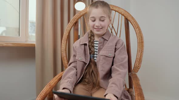 Girl Sitting with a Tablet in Her Hands