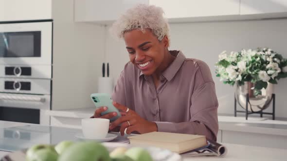 African American Woman Rejoices After Reading SMS on Phone Celebrates Victory alt